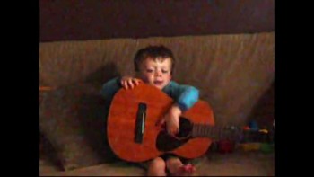 Little boy plays big guitar 