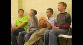 Boys doing a little cheer at a basketball game 
