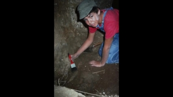 The Ketef Hinnom Silver Scrolls are an artifact that contains what may be the oldest surviving texts from the Hebrew Bible, dating from the First Temple period around the late 7th to early 6th century BCE prior to the Babylonian Exile, and are now preserved at the Israel Museum. The Ketef Hinnom Silver Scrolls were discovered at Ketef Hinnom, an archaeological site southwest of the Old City of Jerusalem, adjacent to St. Andrew's Church, now on the grounds of the Menachem Begin Heritage Center. It is located where the Valley of Rephaim and the Valley of Hinnom meet, on the old road from Jerusalem to Bethlehem. They were discovered inside of ancient burial caves, in 1979 when Gabriel Barkay was excavating an area on the outskirts of Jerusalem in the backyard of St. Andrews church. He had a group of 12 and 13 year old kids helping him. They discovered some tombs, but they were empty—having been looted long ago. One boy, Nathan, was given the task of cleaning out the dirt from the nooks under the burial benches. Like a true boy, he started banging the nook with a hammer. It broke, revealing an entrance to a secret chamber containing more than 1000 objects. There were 125 objects of silver, 40 iron arrowheads, gold, ivory, glass, bone, 150 semi-precious stones, and skeletons. The objects dated to the late 7th and early 6th centuries BC. Among the objects were two, tiny rolled-up silver scrolls 1” long.