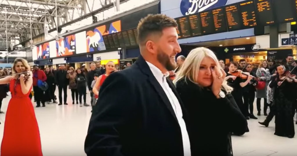 Surprise Orchestra Flash Mob Proposal At Busy Train Station