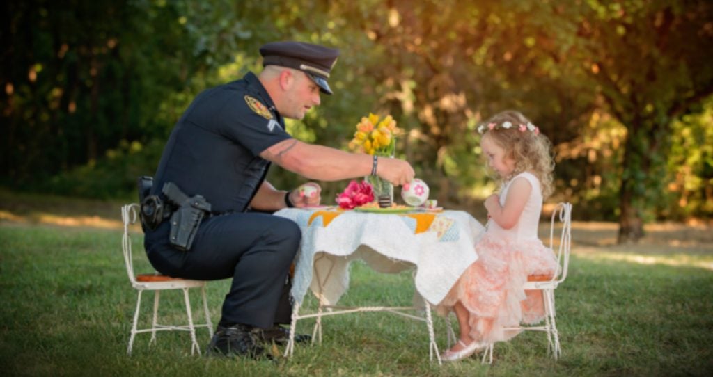 godupdates police officer joins tea party with little girl he saved fb