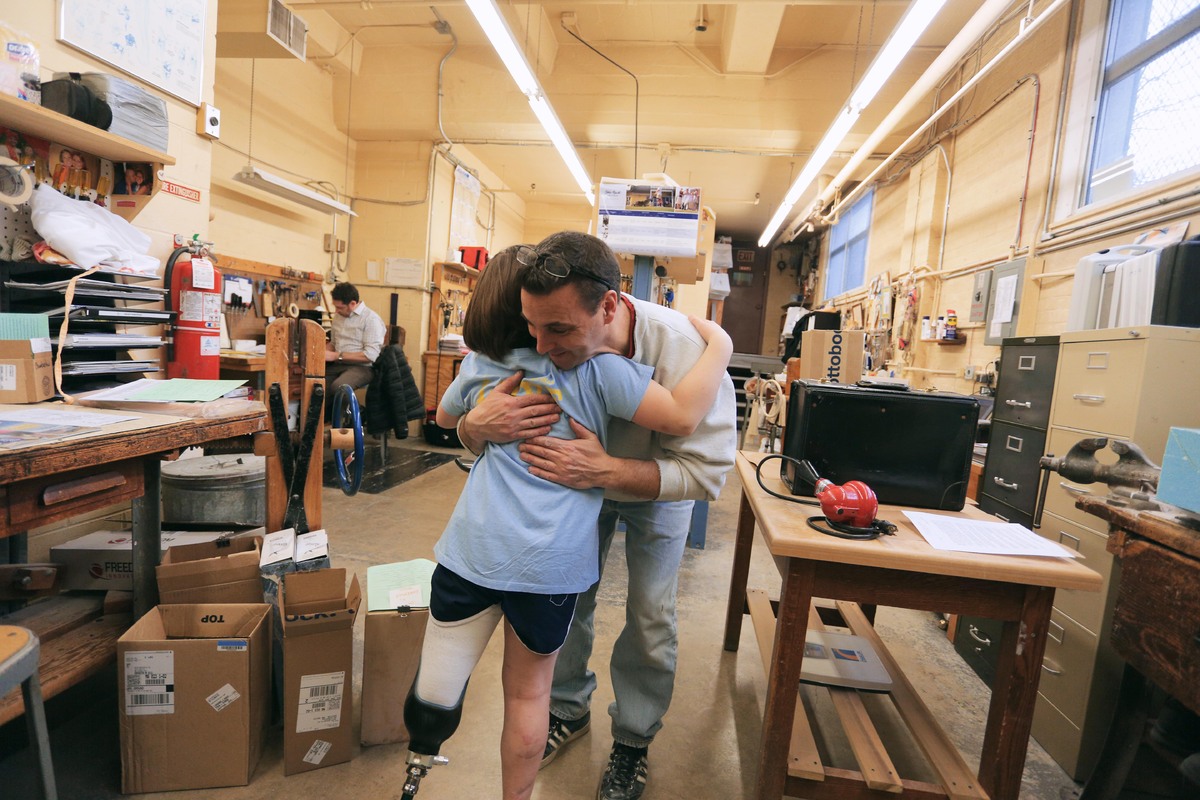 Jane hugs the man who fit her for the prosthetic leg. 